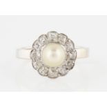 A pearl and diamond cluster ring, set with a central pearl, surrounded by a border of twelve old cut