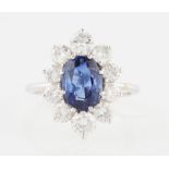 A sapphire and diamond cluster ring, set with a central oval cut sapphire, measuring approx. 10x7mm,