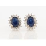 A pair of contemporary sapphire and diamond cluster stud earrings, each set with an oval cut