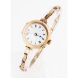 A ladies 9ct yellow gold cased wrist watch, the white dial with hourly Roman numerals and minute