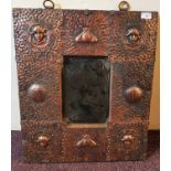 An Arts and Craft copper framed wall mirror decorated in each corner by masks, overall size 62cm x