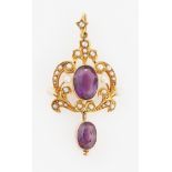 An early 20th Century amethyst and seed pearl pendant, of open metalwork design, stamped 15ct,