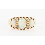 An opal and diamond ring, set with three graduated oval cut opal cabochons with rose cut diamond