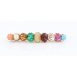 A nine stone multi gemstone bar brooch, gemstones include a turquoise cabochon, ruby, emerald,