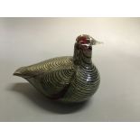 A glass bird by Ovia Toikka, silver on a red base.