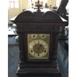 A large oak cased bracket clock, brass and enamel dial with fluted column front.