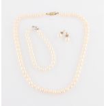 A string of cultured pearls, open metalwork clasp stamped 14k, together with a pair of stud