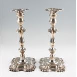 A pair of Edwardian silver weighted candlesticks, the knopped stem and foot featuring fluted design,