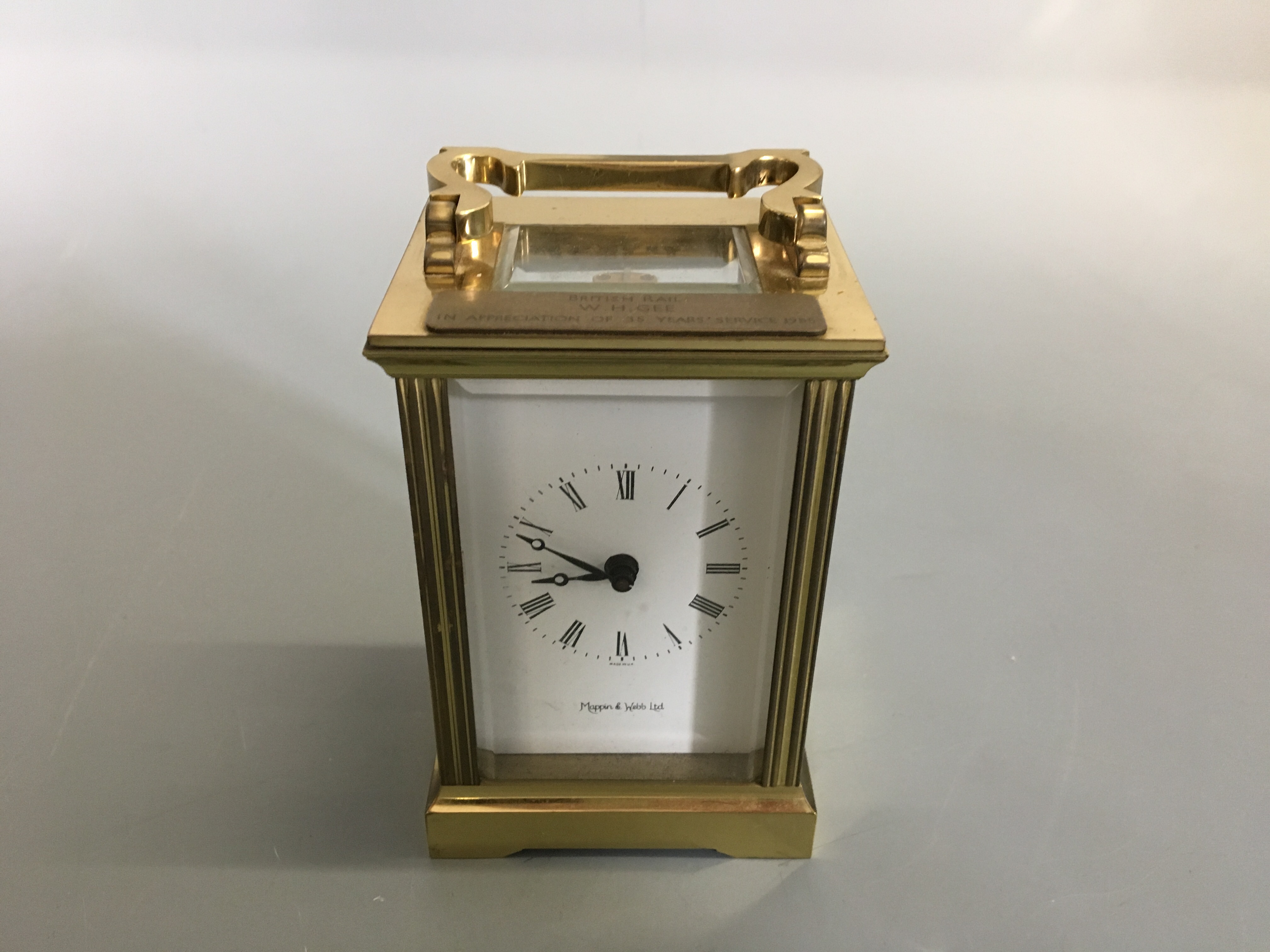 A Mappin and Webb brass cased carriage clock, and bevel glass panels.