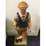 A resin figure of a vintage style golfer.