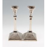 A pair of silver candlesticks, of column form with plain stem on stepped foot, both hallmarked