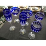 Six Waterford blue bohemian glasses in varying shapes.