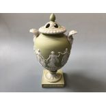 A Wedgwood sage green two handled urn, titled The Dancing Hours' with pierced lid, height 29cm.