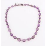 An amethyst riviere necklet, set with 30 graduated oval cut amethysts, largest measuring approx.