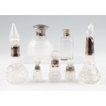 A collection of perfume bottles and dressing table pots, five hallmarked silver lidded or
