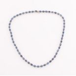 A contemporary sapphire and diamond necklet, comprising of 55 oval cut sapphires, each measuring