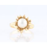 A 1970s style organic design pearl ring, set with a central pearl surrounded by organic form open