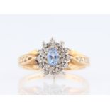 A 9ct yellow gold sapphire and diamond cluster ring, set with a central oval cut sapphire, measuring