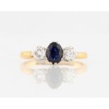 A sapphire and diamond three stone ring, set with a central oval cut sapphire, measuring approx.