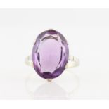 An amethyst dress ring, set with an oval cut amethyst, measuring approx. 17x12mm, set in unmarked