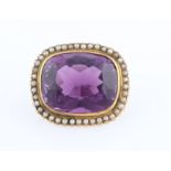 An amethyst and seed pearl brooch, set with a cushion cut amethyst measuring approx. 23x18mm,