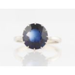 A synthetic sapphire ring, set with a central round cut synthetic sapphire, stamped 18ct, ring