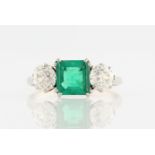 A synthetic emerald and diamond three stone ring, set with a central square cut synthetic emerald,