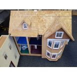 A wooden, three story dolls house with furniture, height 84cm, width 83cm, depth 53cm.