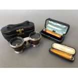 A pair of opera glasses in leather case together with two 9ct banded cigar holders in case.