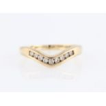 A 9ct yellow gold diamond wishbone ring, channel set with nine graduated round brilliant cut