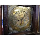 An oak cased grandfather clock with brass engraved dial.