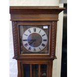 An oak long-cased clock with Westminster chimes.