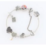 A Pandora charm bracelet, with six attached charms and a safety chain charm.