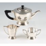 A three piece tea set, comprising a teapot, a sugar bowl and milk jug, all stamped Silver