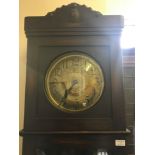 An oak long cased clock with brass dial and glass front.