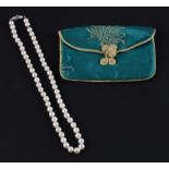 A standard short string of cultured pearls, clasp stamped Silver, housed in a silk purse, (A/F pearl