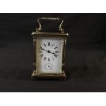 A French, brass carriage clock with enamelled front and Roman numerals to face.