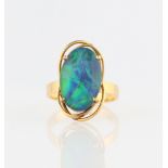 A black opal triplet ring, set with an oval black opal triplet, with an open metalwork surround,