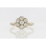 An early 20th Century diamond flower cluster design ring, set with seven old cut diamonds, total