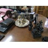 A collection of silver plates ware, small mantle clock, glass decanter and carved wood figure.