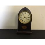 A mahogany mantle clock with gothical form, bun feet and Roman numerals to face.