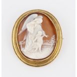 A cameo brooch, depicting angel and child, in an engraved yellow metal frame, brooch measures