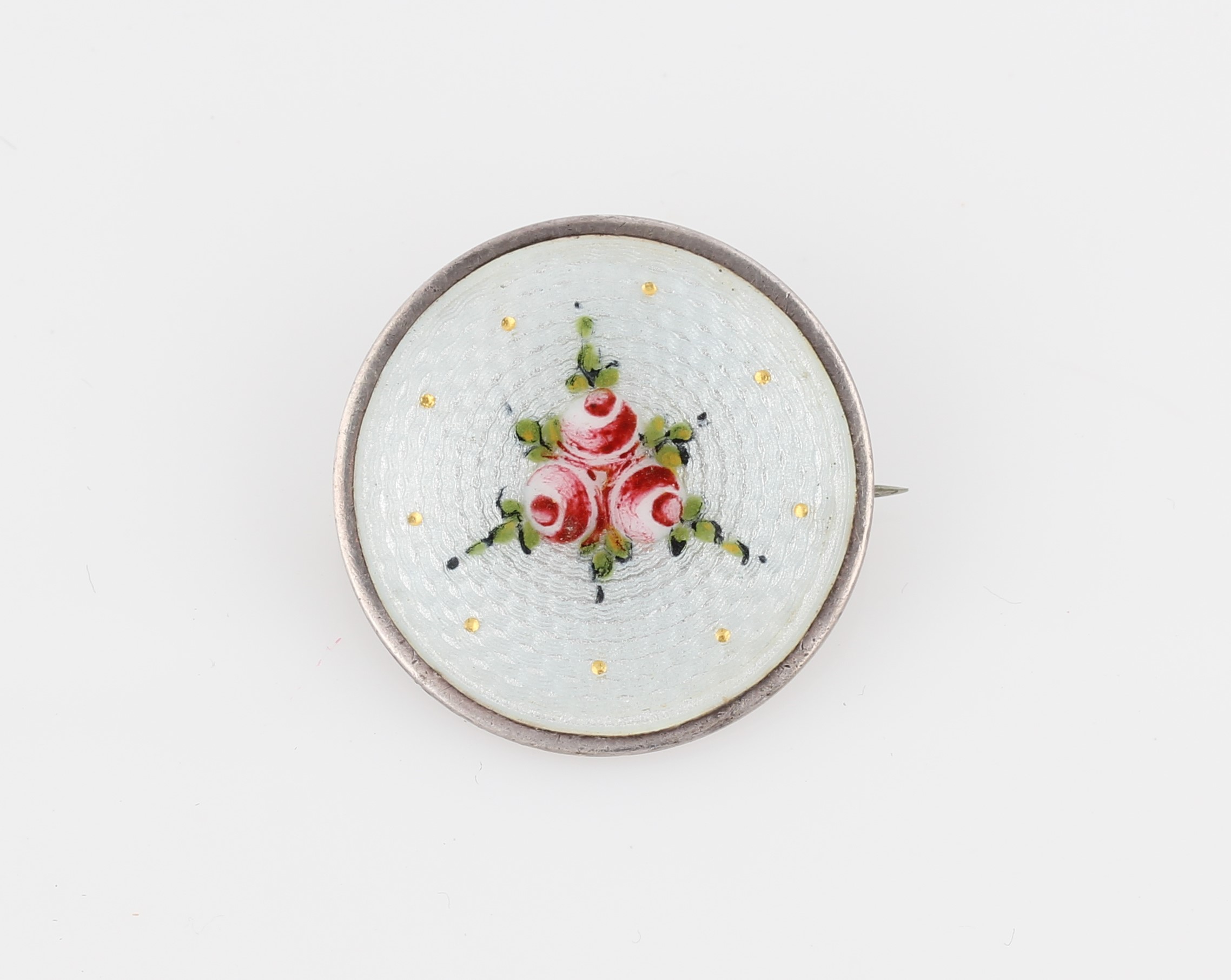 A Charles Horner silver enamel brooch, of circular design featuring floral pattern on white