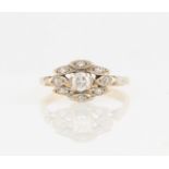 A diamond ring, set with a central round brilliant cut diamond surrounded by diamond accents set