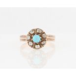 A turquoise and diamond cluster ring, set with a circular turquoise cabochon, surrounded by a border
