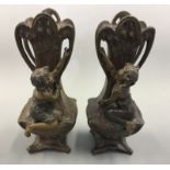 Two Art Nouveau style bronze finished vases, with boy and girl figurines to front. Height 33cm. AF