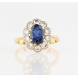 A sapphire and diamond cluster ring, set with a central oval cut sapphire, measuring approx.