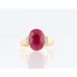 A ruby and diamond ring, set with a central oval cut ruby (possibly treated), measuring approx.