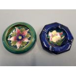 A blue floral Moorcroft ashtray together with a Moorcroft dish with floral interior pattern.