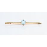 An aquamarine bar brooch, set with an oval cut aquamarine, measuring approx. 10x7mm, stamped 15ct,